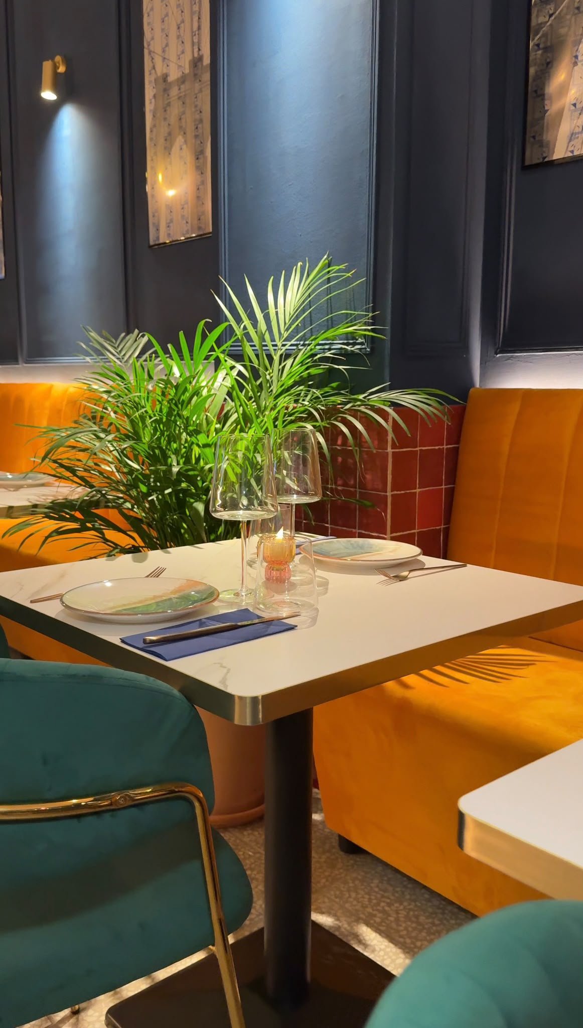 Mesa con velas junto a las plantas en el comedor de AURA